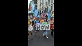 Marchers on UK's biggest ever rally for nature & climate hold banners and flags asking the government to