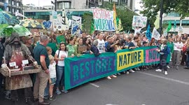 Stewards manage the crowd as celebrities assemble at the start of the UK's biggest ever march for nature & climate