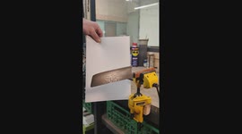 Testing the sharpness of a handmade kitchen knife by gently pushing a thin paper through the sharp edge of the knife.