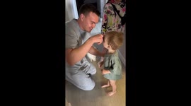 Playful parenting moment: child hilariously 'chokes' parent during play