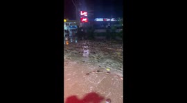 Coconut husks float in muddy soup down flooded road