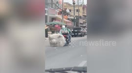 Delivery rider drags huge parcel behind motorbike