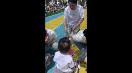 Parents and toddlers take part in watermelon eating race for sports day