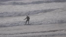 UK Weather Gales and Wind follow hottest days of the year. Kite surfer rides the wild waves Fistral Beach, Cornwall UK