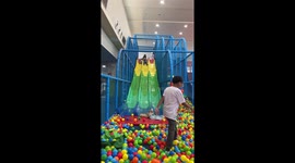 Joyful aunt protectively embraces niece on slide in San Fernando, Philippines