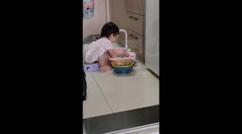 Sweet baby girl helps her mother wash green beans for dinner