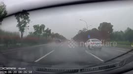 Driver spins out of control on wet road during rain