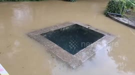Clear well water stands out amidst muddy flooded river in China