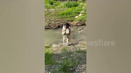 Woman slips on rocks while crossing stream