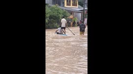 Locals use stand-up paddleboard to negotiate floods in Phuket, Thailand