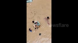 Chinese rescuers carry elderly resident through neck-deep floodwater amid rainstorm