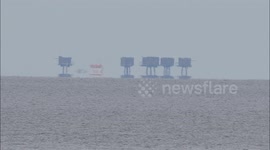 Ship appears to levitate in front of Shivering Sands Forts off Kent, UK