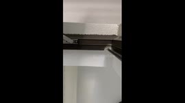 Tiny Chinese mouse peeks from wall hole