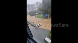 Employees rescue pensioner caught in Chinese floodwaters