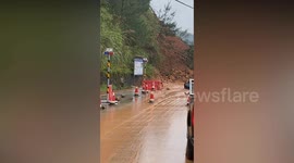 Onlookers run to safety as massive landslide covers road