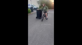 Cyclist loses control while pulling trash bin