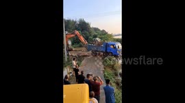 Trucks loaded with stones successfully block breach caused by floods in southern China