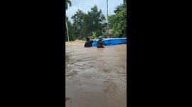 Family use inflatable paddling pool to save children in floods in Malaysia