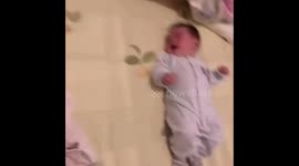 Baby teaches twin brother how to roll over in China