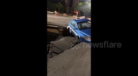 Terrifying moment taxi dangles over huge sinkhole after road collapses in China