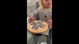 Little girl conquers peg solitaire with skill and comedic talent