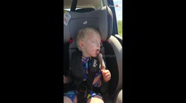 Little boy struggles to eat an ice cream after a day at the beach