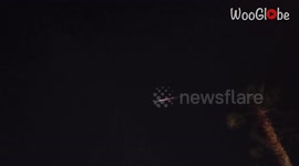 Meteor falling against a black backdrop mesmerizes a woman