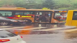 Bus driver washes mop in road rainwater for cleaning vehicle