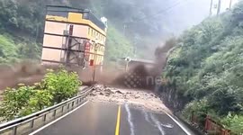Vehicles and pedestrians flee as mudslide crashes onto road in southern China