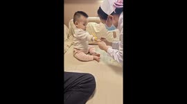 Calm baby remains unfazed while receiving injection