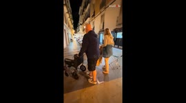 Playful dad makes the family laugh by moving mom's wheelchair away repeatedly