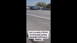 Passing motorists hand water bottles to woman battling wildfire on highway in California