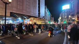 England football fans celebrating the win against the Netherlands turn Piccadilly Circus into an impromptu football pitch