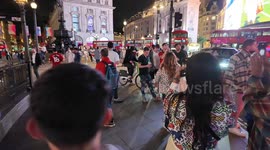 England football fans celebrating the big win against the Netherlands turn Piccadilly Circus into an impromptu football pitch