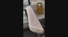 Finishing touch, oiling up the handle of a yellow honeycomb kitchen knife.