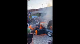 Karachi car fire: person retrieves items amid blaze