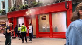 Smoke engulfs Carnaby Street as Ray Ban store evacuated as onlookers gather in shock. Two fire engines and firemen arrive to the scene.