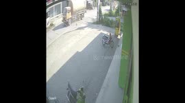 Moment of bullfighting accident between a large truck and a motorbike in Indonesia. The motorbike rider survived even though he was run over by a large truck