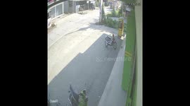 Moment of bullfighting accident between a large truck and a motorbike in Indonesia. The motorbike rider survived even though he was run over by a large truck