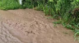 Schoolchildren walk through floods as forecasters warn of heavy rain across Thailand