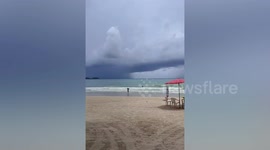 Waterspout tornado whips in sea beside scary storm