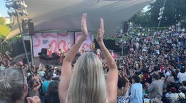 Blond Swedish woman in big crowd dancing cumbia in the live show of Los Mirlos from Peru at Malmö Sommarscen, Sweden.