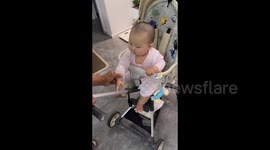 China: Baby Clings to Stroller Rail