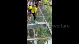 Sanitation workers at Chinese scenic area calmly clean high-altitude glass skywalk