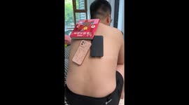 Chinese man's sweaty back turns sticky as objects adhere