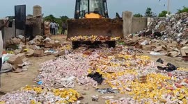 Police use excavator to destroy over 10,000 bottles of illegal alcohol in southern India