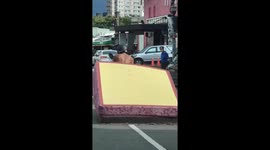 Rider carries huge mattress foam with motorbike on road