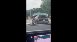Motorist HOLDS onto mattress balanced on roof without strapping