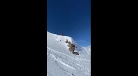 snowboarder slams a cat track after dropping a cliff