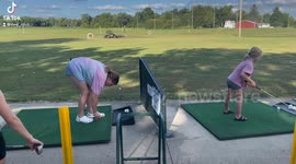 girl hits a golf ball, golf ball hits her in the mouth